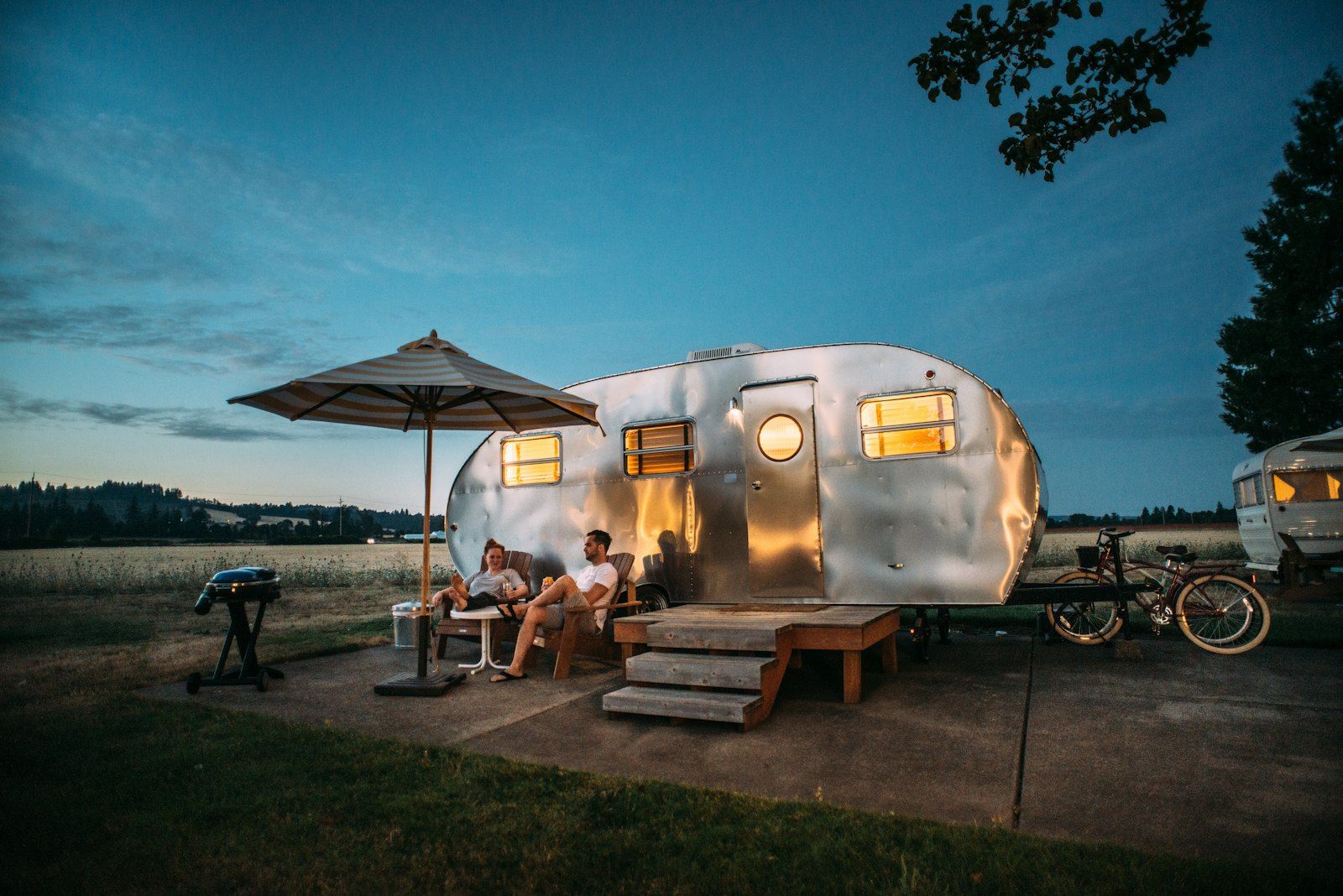 Airstream RV parked at a campground at dusk