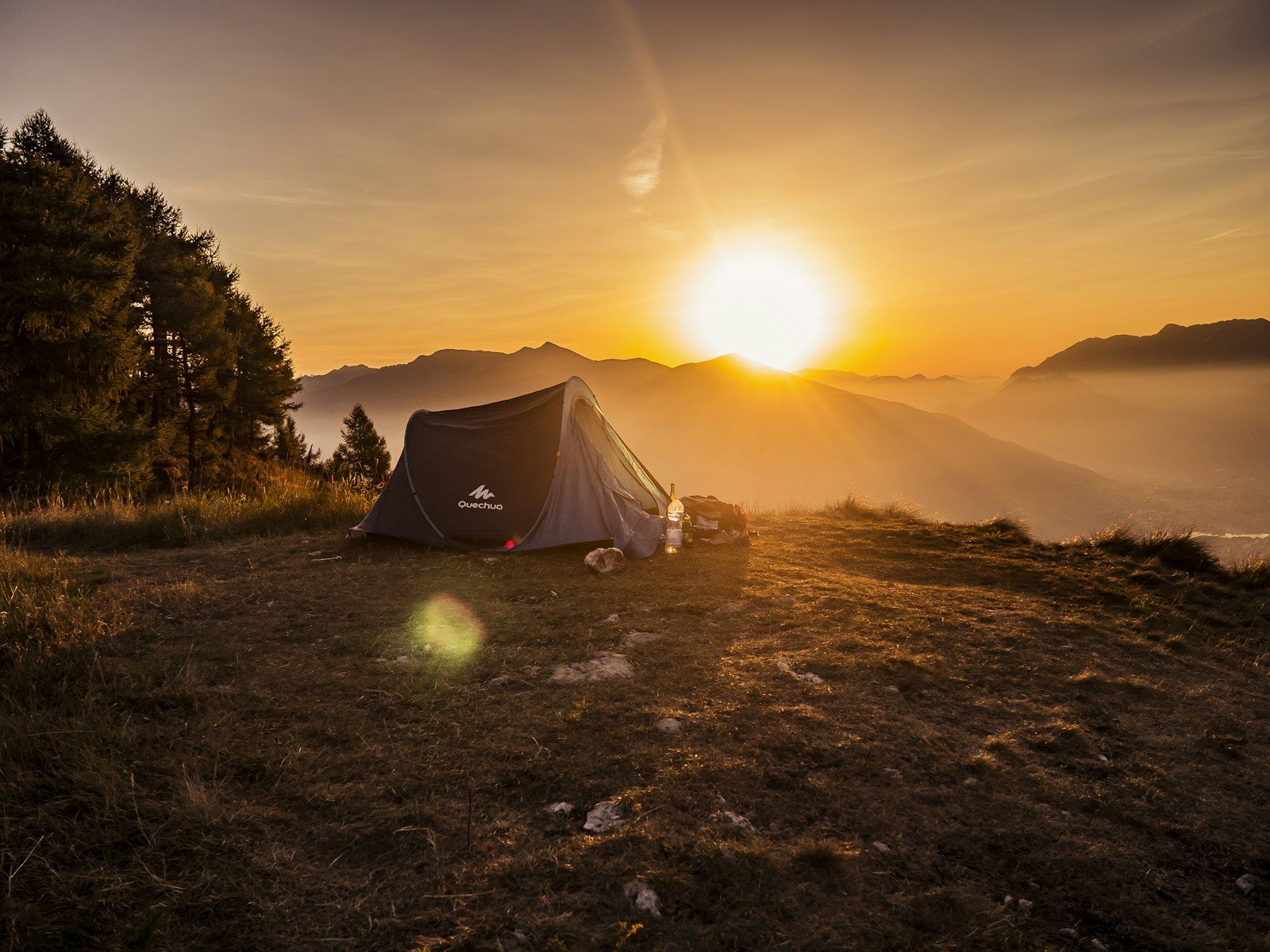 Tent silhouetted at mountain sunset